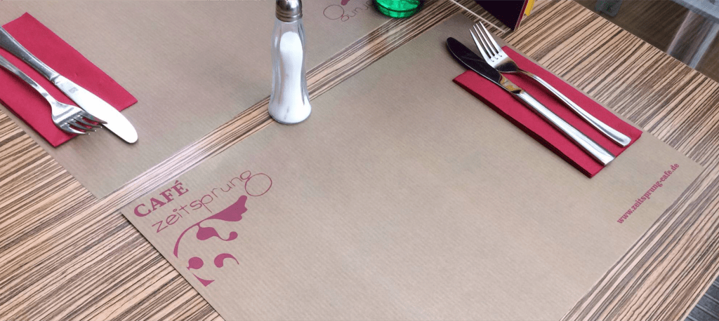 Individuell bedruckte Unterleger mit rotem Logo auf Kraftpapier für das Café Zeitsprung in Trier