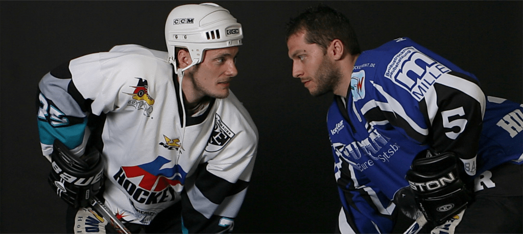 Hockeyspieler stehen sich zu einem Duell gegenüber.