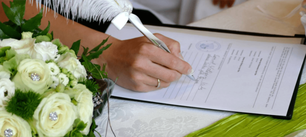 Braut unterschreibt beim Standesamt